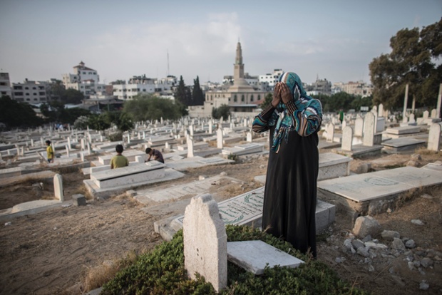 Seorang perempuan Palestina menangis di kuburan keluarga di jalur Gaza | Foto: Oliver Weiken/EPA