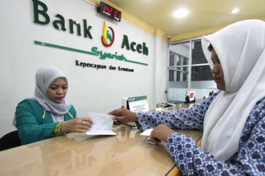 Teller Bank Aceh Syariah yang berlokasi di Kecamatan Kuta Alam, Banda Aceh, melayani nasabah, Kamis (19/9). SERAMBI/BUDI FATRIA